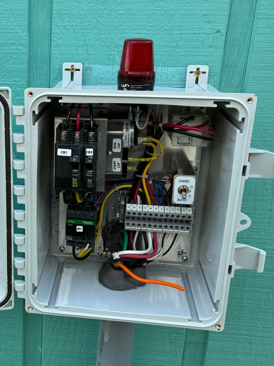 Commercial pump control panel wired inside an outdoor NEMA enclosure, with breakers, terminal blocks, and an alarm light